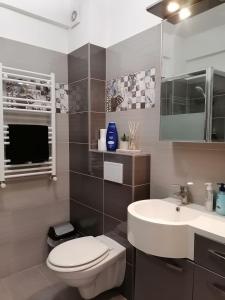 a bathroom with a white toilet and a sink at Apartament Porto Del Mar in Mamaia Sat/Năvodari