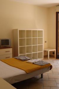 - une chambre avec un grand lit et une télévision dans l'établissement Studio Sole e Residenza Luna Assisi, à Assise