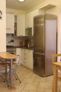 - un réfrigérateur en acier inoxydable dans une cuisine avec une table dans l'établissement Studio Sole e Residenza Luna Assisi, à Assise