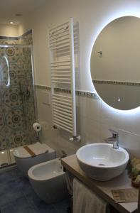 a bathroom with a sink and a toilet and a mirror at Divina Holiday - Apartments in Maiori
