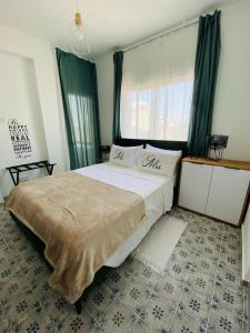een slaapkamer met een groot bed en een raam bij Simple One bedroom flat in Engomi in İncirli