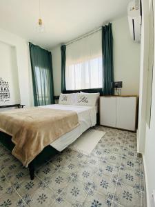 ein Schlafzimmer mit einem großen Bett und Fliesenboden in der Unterkunft Simple One bedroom flat in Engomi in İncirli