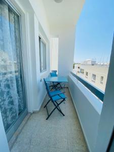 uma varanda com uma mesa azul e uma janela em Simple One bedroom flat in Engomi em İncirli