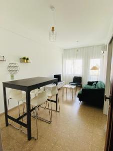 sala de estar con mesa negra y sillas blancas en Simple One bedroom flat in Engomi, en İncirli