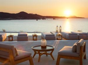 a living room with a view of the ocean at sunset at Domes White Coast Milos, Adults Only - Small Luxury Hotels of the World in Mytakas