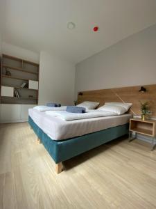a bedroom with a large bed and a wooden floor at APARTAMENTY ZDROJOWA 9 in Duszniki Zdrój