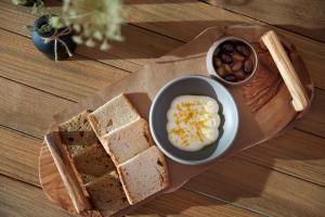 a plate with bread and a bowl of eggs and nuts at Domes White Coast Milos, Adults Only - Small Luxury Hotels of the World in Mytakas