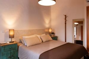a bedroom with a large bed with green cabinets and a lamp at Casas de Campo do Castro da Cola in Marchicão