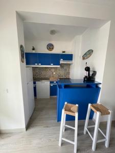 ポルティマンにあるEdificio Safira Praia da Rochaのキッチン(青いキャビネット、スツール2脚付)