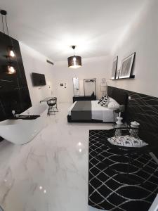Habitación blanca grande con cama y sofá en B&B Secret Suite, en Gallipoli