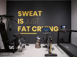 a room with a gym with exercise equipment on the wall at Domes White Coast Milos, Adults Only - Small Luxury Hotels of the World in Mytakas