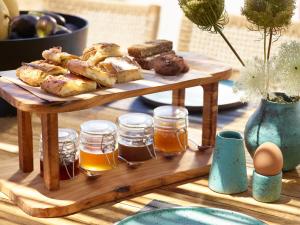 a wooden tray with pastries and honey on a table at Domes White Coast Milos, Adults Only - Small Luxury Hotels of the World in Mytakas