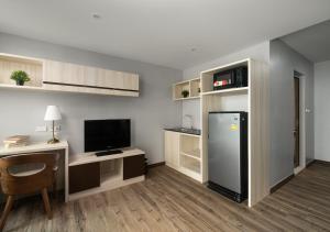 uma cozinha com um frigorífico e uma secretária com uma televisão em VSK RESIDENCE - SHA Extra Plus em Lat Krabang
