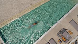a man swimming in a pool in a swimming pool at Domes White Coast Milos, Adults Only - Small Luxury Hotels of the World in Mytakas