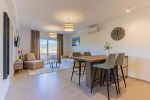 a kitchen and living room with a table and a clock at Villa Orhideja in Cres