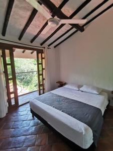 a bedroom with a bed and a large window at Las Cabezas Grises in Barichara