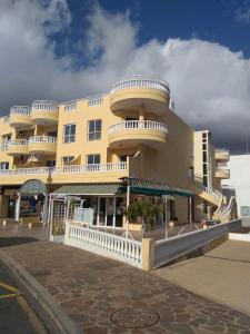 duży żółty budynek z balkonami na ulicy w obiekcie Club La Mar w mieście Puerto de Santiago