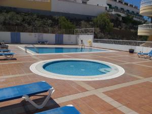duży basen na patio ze stołem i krzesłami w obiekcie Club La Mar w mieście Puerto de Santiago