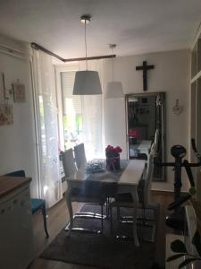 a dining room with a table and chairs and a cross on the wall at Studio apartman Zagreb zapad Vrapče in Zagreb