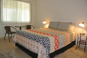 博雷戈斯普林斯Borrego Springs Motel的一间卧室，配有一张床、一张桌子和几把椅子