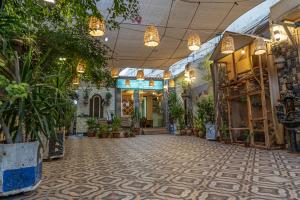 亞喀巴的住宿－Al Riyati Hotel Apartments，商店的过道,有盆栽植物和灯