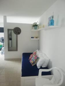 um quarto com uma cama com um espelho e uma cadeira em Hermoso apartamento frente al Mar Caribe em Cartagena de Indias