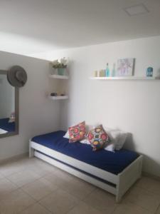 um quarto com uma cama com lençóis e almofadas azuis em Hermoso apartamento frente al Mar Caribe em Cartagena de Indias