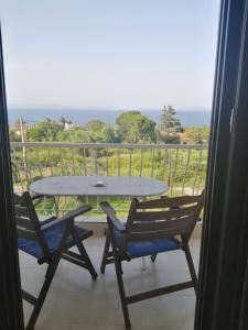 a table and two chairs on a balcony with a view at Avra Ηouse in Kriopigi
