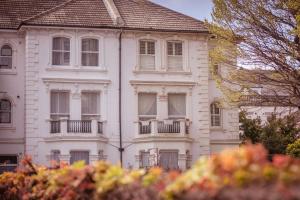 um edifício branco com janelas e um telhado em Little Chelsea Beacon - chic & central flat with parking em Eastbourne