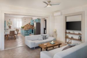 a living room with two white couches and a table at WATERFRONT SEA DREAM VILLA in Milna
