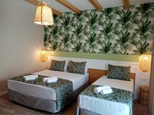two beds in a room with a mural on the wall at Dolphin Park Hotel in Ortaca