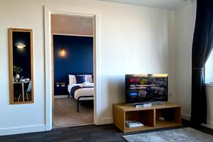 - une chambre avec un lit et un miroir dans l'établissement Middlehaven Apartment, à Middlesbrough