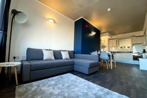 a living room with a blue couch and a kitchen at Middlehaven Apartment in Middlesbrough
