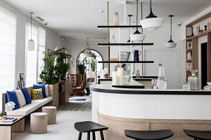 een woonkamer met een bar met stoelen en tafels bij Le Riviera Collection, Signature Collection by Best Western in Nice