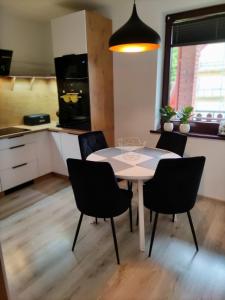 a kitchen and dining room with a table and chairs at Apartament Szumi Las Kletno in Kletno