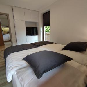 a bedroom with a large bed with a black pillow at Apartament Szumi Las Kletno in Kletno