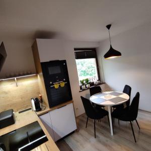 a kitchen and dining room with a table and chairs at Apartament Szumi Las Kletno in Kletno