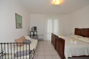 a bedroom with two beds and a couch in it at B&B LA CASA DEL CASALE in Roseto degli Abruzzi
