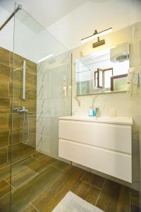 een badkamer met een wastafel en een glazen douche bij Hotel Imperial in Dhërmi