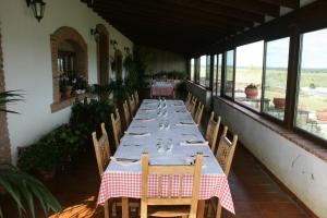 a dining room with a table and chairs and windows at Casa Rural Las Canteras in Trujillo +13 photos