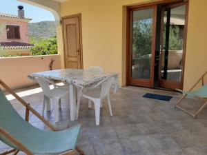 Una mesa blanca y sillas en un patio. en Sa Pira, en Budoni