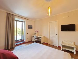 a bedroom with a bed and a desk and a television at Casa Fifina Rooms in Sant'Egidio del Monte Albino