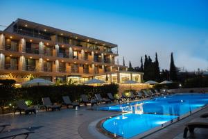 a hotel with a swimming pool in front of a building at Apollon Hotel in Tolo