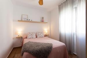 - une chambre avec un lit avec deux oreillers et une fenêtre dans l'établissement APARTAMENTO VIRGEN DEL CARMEN, à Chipiona