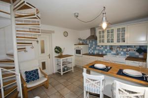une cuisine avec une table, des chaises et une échelle dans l'établissement Lovely House with View Over Salt Pans TIMOR, à Sečovlje 21 autres photos