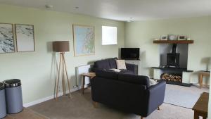 a living room with a couch and a fireplace at Dairy Cottage with sea views in Girvan