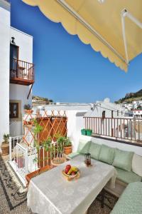 a living room with a table and a couch on a balcony at Lindian Jewel Exclusive Apartments in Lindos