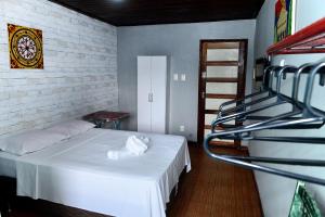 - une chambre avec un lit blanc et une échelle dans l'établissement Pousada Cor e Arte - Pelourinho, à Salvador