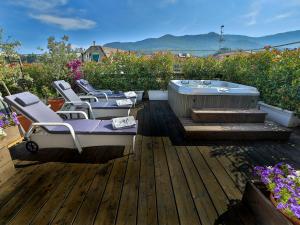 um deque com cadeiras e uma banheira de hidromassagem no telhado em Hotel Tigullio Et De Milan em Santa Margherita Ligure