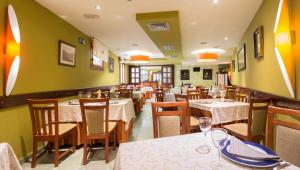 ein Restaurant mit Tischen und Stühlen und grünen Wänden in der Unterkunft Gran Hotel Rural Cela in Belmonte de Miranda